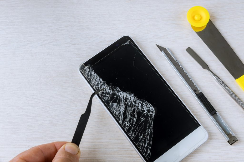Broken phones on cracked screen details of the cell phone repair tools
